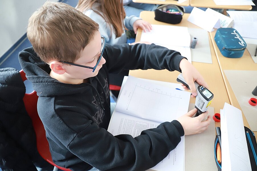 Julius Michel (7R3) misst die Temperatur des Taschenofens mit einem Infrarotthermometer.